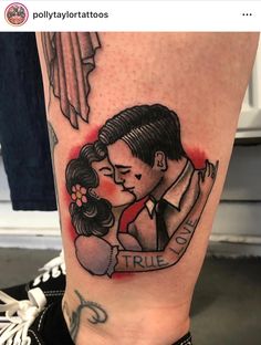 a tattoo on the leg of a woman with a man kissing her forehead and holding his arm