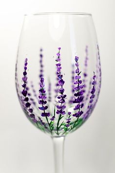 a wine glass with purple flowers painted on it