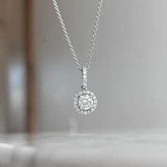 One (1) 18K White gold round diamond halo pendant prong set with (1) 48/100CT center diamond of fine (I) color and (SI1) clarity and (23) round brilliant cut diamond 18/100CTW of fine (G) color and (VS2) clarity. This necklace can be customized to fit your needs. Please give us a call at 314-548-5100 to have your custom order placed. **10K and 18K and larger stone sizes available by request. Classic Halo Diamond Necklace In Cubic Zirconia, Classic Cubic Zirconia Diamond Necklace With Halo, Classic Cubic Zirconia Halo Diamond Necklace, Formal Diamond Solitaire Necklace With Halo Design, Halo Diamond Necklaces With Round Shape, Round Diamond Halo Necklaces, Cubic Zirconia Halo Diamond Necklace, Classic Cubic Zirconia Solitaire Necklace With Halo Design, Classic Diamond White Necklace With Halo