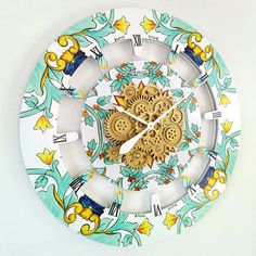 a white clock with blue and yellow designs on it