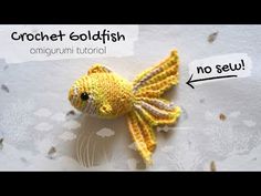 a crocheted goldfish with an arrow pointing to it's left side