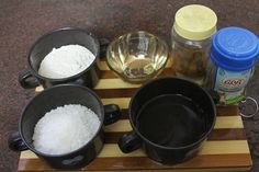 three pots with sugar and other ingredients on a cutting board