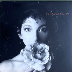 a black and white photo of a woman holding a rose in her mouth with the words, the sinja world - kate bush