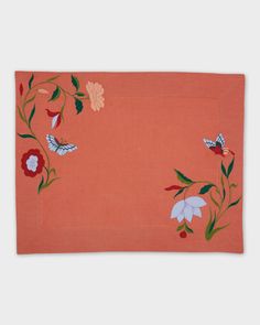 an orange placemat with flowers and butterflies on it