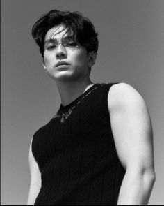 a black and white photo of a woman with short hair wearing a sleeveless top