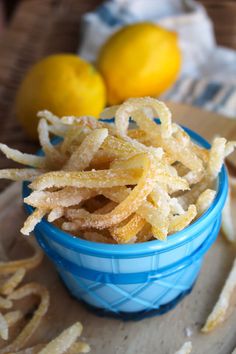 a blue bowl filled with fried food next to lemons