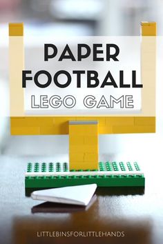 a lego football game sitting on top of a table next to a book and pen