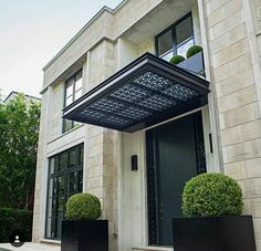 the front door of a large building with two black planters