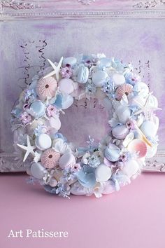 a wreath with seashells and starfish on it sitting in front of a painting