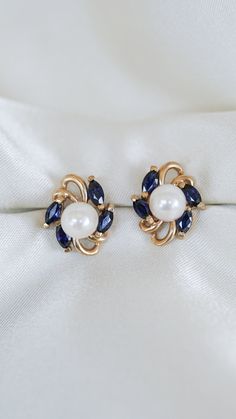 * Earring Material: Sapphire, Pearl, 14K Yellow Gold  * Earring Dimensions:0.5x0.5 Inch,   * Stone Weight & sizes: 8 Blue Sapphire - 1.04ct, Pearl - 6.5-6.7MM  * Earring material: 14k yellow gold, Post Push Back with Jackets   * Overall weight: 3.7g Blue Cluster Earrings For Anniversary, Blue Round Pearl Earrings For Anniversary, Classic Blue Round Pearl Earrings, Elegant Cluster Gemstone Earrings, Blue Pearl Earrings For Anniversary Fine Jewelry, Classic Blue Pearl Earrings For Anniversary, Blue Pearl Earrings For Anniversary, Elegant Blue Round Cluster Earrings, Elegant Blue Cluster Earrings For Anniversary