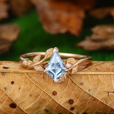 a ring with a blue topazte surrounded by leaves on a fall leaf background