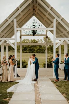 a bride and groom kiss under the gazebo at their outdoor wedding ceremony in texas