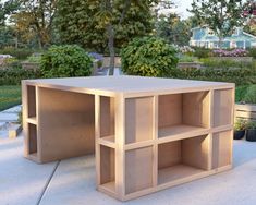 a wooden table sitting on top of a cement ground next to flowers and trees in the background