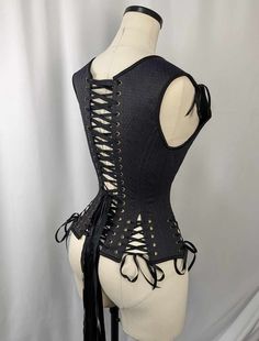 Navy, Black, and Gold Androgynous Low Curve Corset Vest This listing is for a made to order corset made using our custom pattern! Constructed from a stunning Navy on Black Jacquard with gold diamond accents and a cotton twill liner, this corset is perfect for victorians, goths, and the renaissance faire alike.  This corset is made of a Black and Navy Jacquard with a Gold Diamond Pattern, tied together with Black binding,  Black stitching, Black laces and bronze colored hardware. Our 435 Pattern is a low curve corset vest that is perfect for all day wearers, newer corset wearers as well as customers who are looking for a flattering shape on many different body styles! Adjustable shoulders and hip ties in the front and back mean that this corset can be tweaked for tons of different body shap Sleeveless Black Boned Bodice, Black Corset Dress With Boning, Black Corset Dress With Boning And Fitted Bodice, Black Fitted Gothic Corset Dress, Steampunk Fitted Corset For Wedding, Steampunk Fitted Wedding Corset, Steampunk Wedding Fitted Corset, Elegant Corset With Boning For Costume Party, Black Fitted Corset Belt For Costume