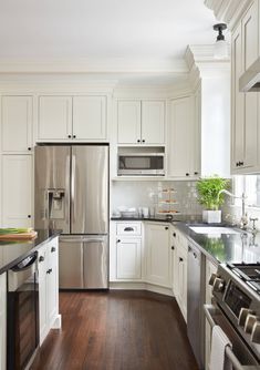 a kitchen with white cabinets and stainless steel appliances