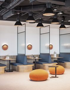 an empty conference room with blue chairs and orange bean bags on the floor in front of large mirrors