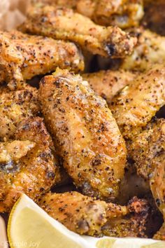 chicken wings with lemon wedges and seasoning in a basket, ready to be eaten