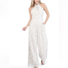 Beautiful Knot Neck Halter Lace Jumpsuit In An Ivory Lace With Nude Lining. Slight Wide Leg, With Side Seam Pockets, Zipper At Center Back With Key Hole And Button Closure At Neck, Fully Lined. 100% Polyester, Hand Wash, With Like Colors, Line- Dry. Elegant Lace Jumpsuits And Rompers For Spring, White Fitted Jumpsuits And Rompers For Formal Occasions, White Fitted Formal Jumpsuits And Rompers, White Fitted Jumpsuit For Formal Occasions, Lace Jumpsuits And Rompers For Wedding, White Sleeveless Jumpsuits And Rompers For Formal, White Sleeveless Jumpsuits And Rompers For Formal Occasions, White Sleeveless Jumpsuit For Formal Occasions, Chic Beige Evening Jumpsuits And Rompers