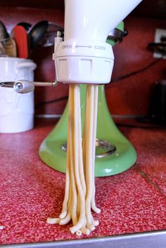 a close up of a mixer with noodles in it