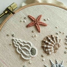 an embroidery project with three different types of seashells and starfish on it