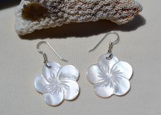 These beautiful earrings feature a carved White mother of pearl shell flower . The iridescence of the Mother of Pearl Shell is really amazing. Depending on the light source they will radiate colors varying from whites to creamy whites. The shells are then polished to a high gloss to reveal the beauty of their natural pattern. Enjoy these lightweight beauties that are so easy to wear. these beach earrings are perfect for everyday and any occasion. DETAILS - Shell types :White Mother of Pearl Shel Silver Shell-shaped Pearl Earrings For Gifts, White Mother Of Pearl Flower Shaped Jewelry, Pearl White Flower Earrings For Gift, White Mother Of Pearl Jewelry With Ear Wire, White Mother Of Pearl Jewelry In Flower Shape, Mother Of Pearl Flower Jewelry For Anniversary, Anniversary Jewelry In Flower Shape With Mother Of Pearl, Anniversary Jewelry Mother Of Pearl Flower Shape, Anniversary Flower Shaped Mother Of Pearl Jewelry