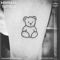 a black and white photo of a small teddy bear tattoo on the left calf leg