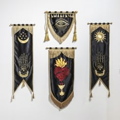 three black and gold wall hangings with hand, heart, sun and hamsa