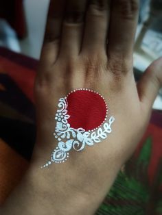 a woman's hand with white and red designs on it