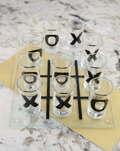 the glasses are arranged on top of the tic - tac - toe board