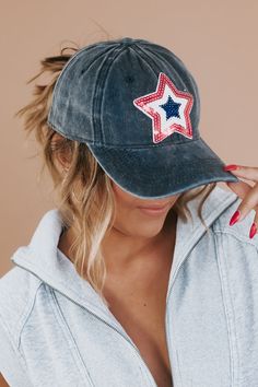 a woman wearing a hat with a star patch on it's visor and red white and blue nail polish