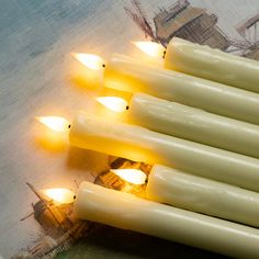 several lit candles sitting on top of a piece of paper