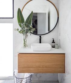 a bathroom with a round mirror above the sink