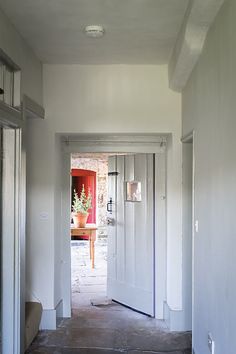 an open door leading into a room with white walls and doors on either side of it