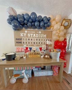 a baseball themed party with balloons and desserts on a table in front of a sign that says ky stadium