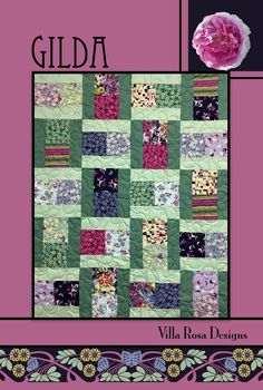 a pink flower sitting on top of a green and purple quilted wall hangings