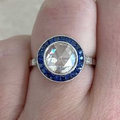 a woman's hand with a blue and white ring on it