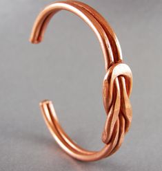 Handmade Solid Copper Cuff Love Knot Bracelet that is Heavy Double 8 Gauge wire sized to fit 7 inch wrist. This is made of Heavy gauge solid copper round wire stock. Interlocking  wire forms this bracelet's Love Knot. It is then pressed in a rolling mill. Easy to clean by using tomato ketchup (slow and safe). Love Knot Bracelet, Handmade Copper Bracelet, Promise Bracelet, Rolling Mill, Wire Cuff, Copper Cuff Bracelet, Copper Cuff, Knot Bracelet, Handmade Wire Jewelry