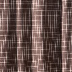 a brown and white checkered curtain hanging from a window