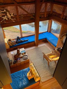 an aerial view of a living room with couches and windows looking out onto the water