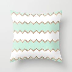 a mint green and white pillow with gold glitter chevrons on the front,