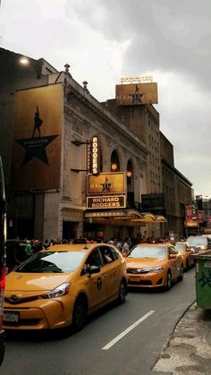 taxi cabs are lined up in front of the marquee theatre on broadway