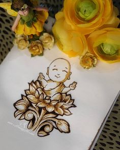 a drawing of a buddha sitting on top of a piece of paper next to yellow flowers