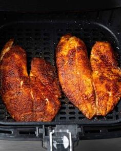 three pieces of chicken cooking in an air fryer