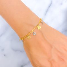 This stylish two-tone charm bracelet is crafted from 22K gold, combining yellow and white gold for a modern and versatile look. It weighs 3.5 grams and measures 7.5 inches in length, making it suitable for a variety of wrist sizes. The interplay of yellow and white gold adds depth and contrast, enhancing the bracelet's visual appeal. Secured with a dependable lobster lock, it ensures the bracelet remains safely on your wrist throughout wear. Ideal for those who appreciate a blend of classic and contemporary styles, this bracelet is perfect for adding a refined touch to both day-to-day and special occasion ensembles. PRODUCT DETAILS Gold Purity(karat): 22k Gold Weight(grams): 3.5 Item Finish: Yellow + White Gold Bracelet Length: 7.5" Lock Style: Lobster Lock Bridal Jewelry Necklace, Precious Stones Rings, Diamond Pendant Sets, Fancy Necklace, Fancy Rings, Modern Bracelets, Mens Gold Rings, Diamond Necklace Set, Stone Bangle