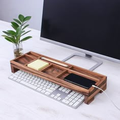 a desk with a keyboard, mouse and cell phone on it next to a monitor