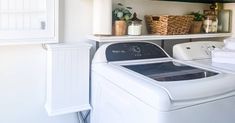 a washer and dryer in a small room with shelves above the washer