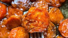 a close up of food on a fork in a pan with sauce and meatballs