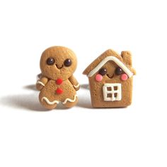 two small gingerbread cookies are next to each other on a white surface, one has a house and the other has a gingerbread