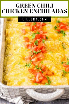 green chili chicken enchiladas in a casserole dish with tomatoes and parsley