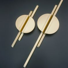 two white plates with gold handles on a blue surface, one is holding chopsticks